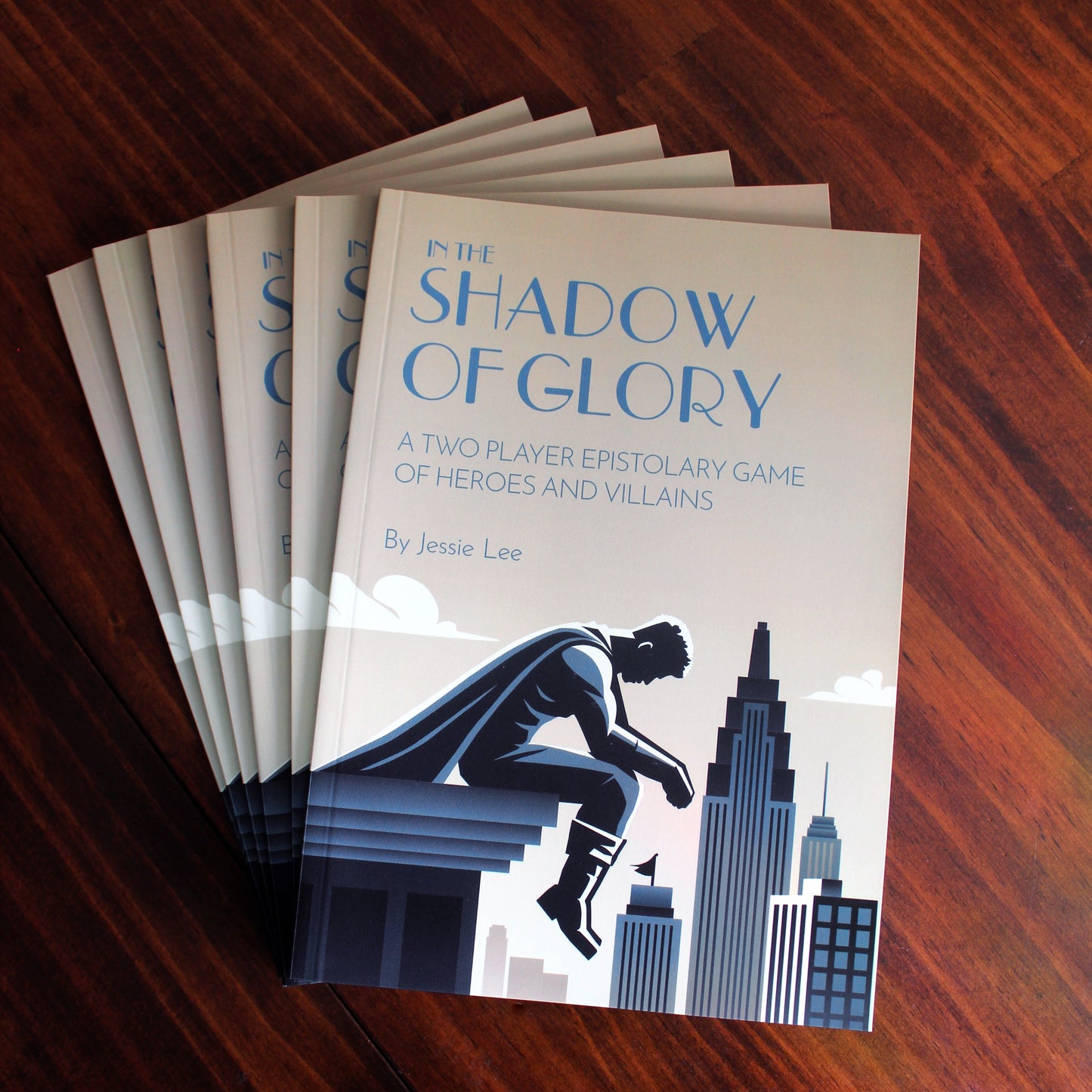 Stack of books titled 'In the Shadow of Glory' on a wooden surface