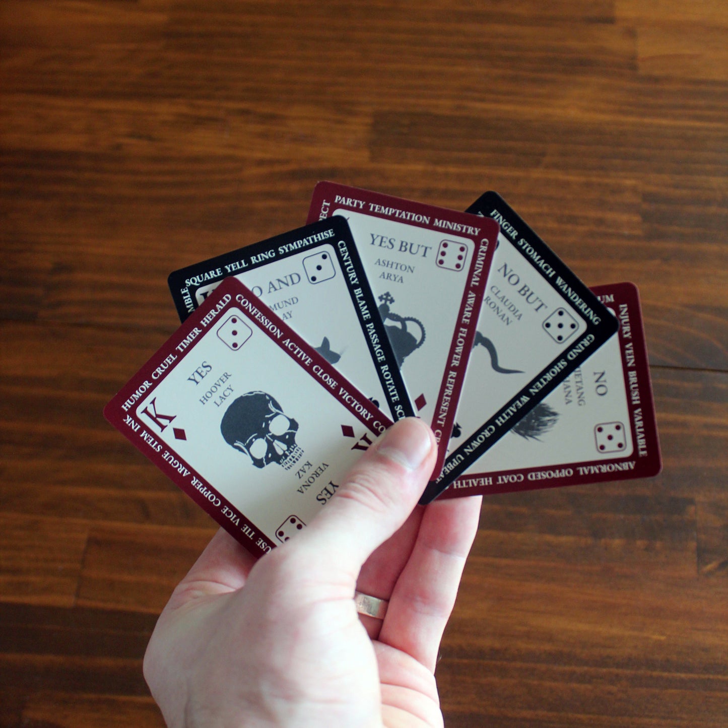 Hand holding playing cards with a wooden surface background