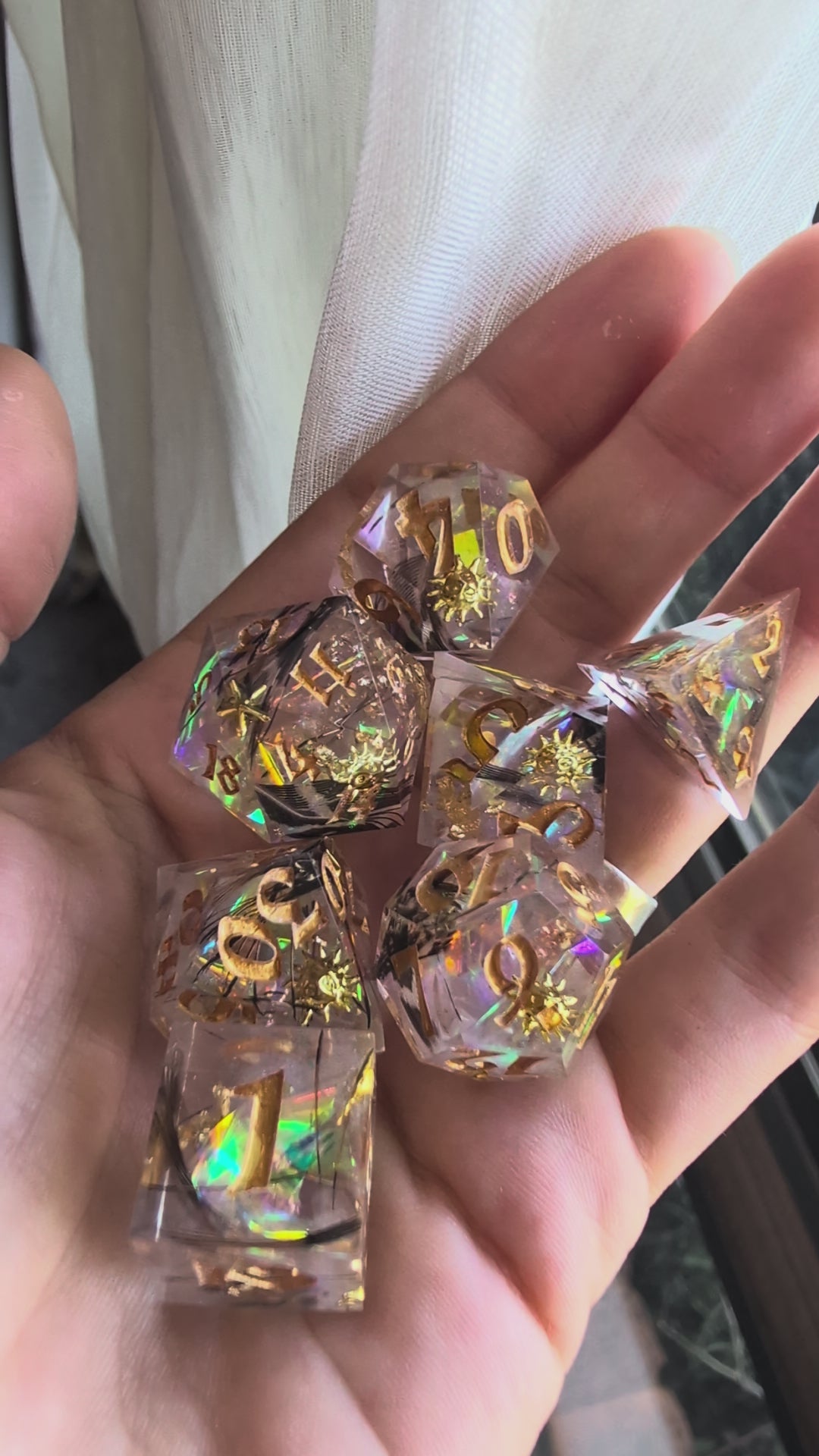 Load video: A set of polyhedral dice in a hand.